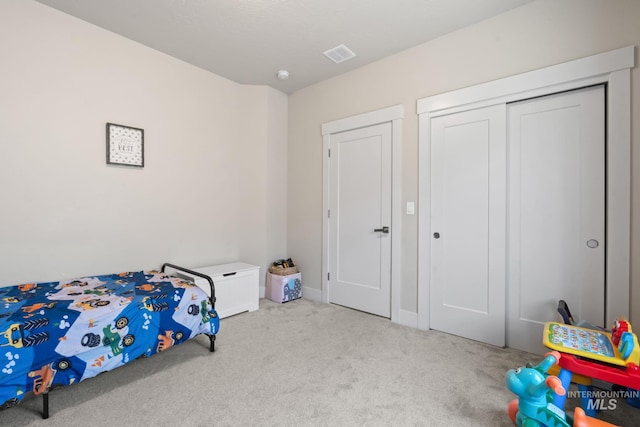 carpeted bedroom with a closet and baseboards