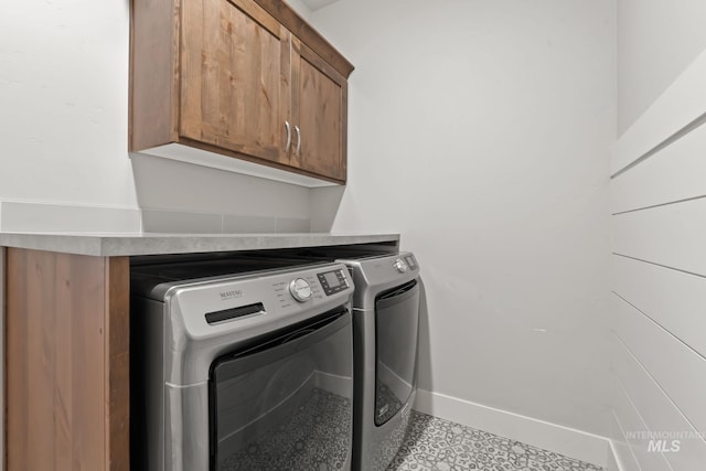 laundry room featuring independent washer and dryer, cabinet space, and baseboards