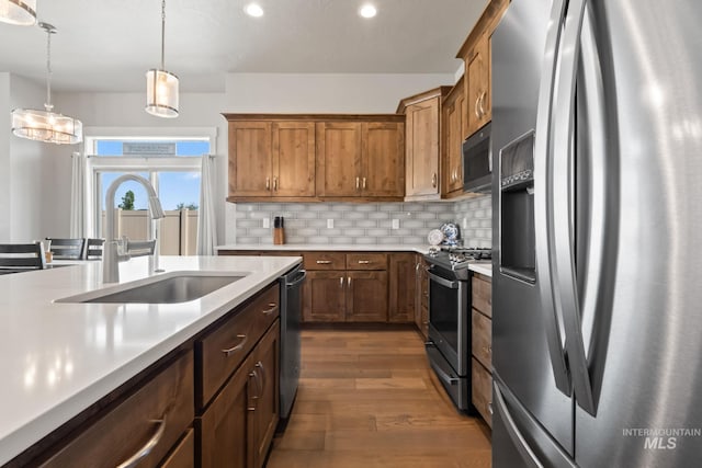 kitchen with stainless steel appliances, light countertops, dark wood-type flooring, recessed lighting, and a sink