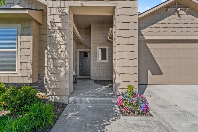 entrance to property with an attached garage and driveway