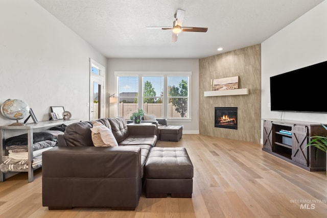 living area with a large fireplace, ceiling fan, light wood finished floors, and recessed lighting