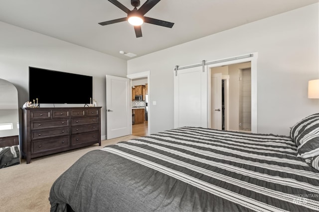 bedroom featuring light carpet, a ceiling fan, and a barn door