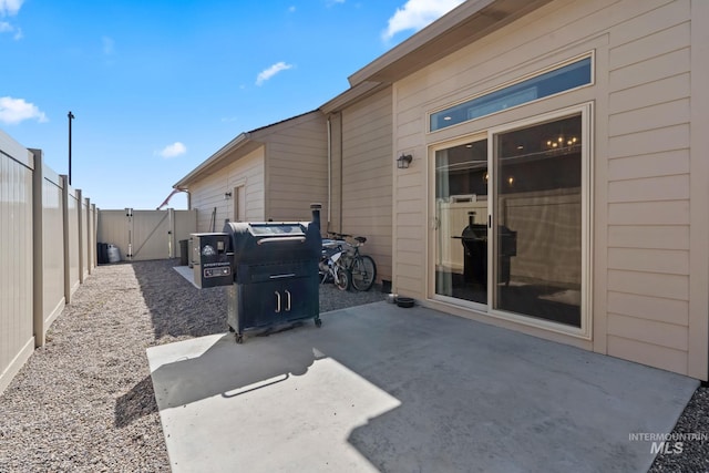 view of patio / terrace with a gate, a fenced backyard, and grilling area