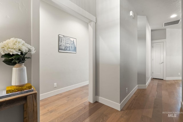 corridor with wood finished floors and baseboards