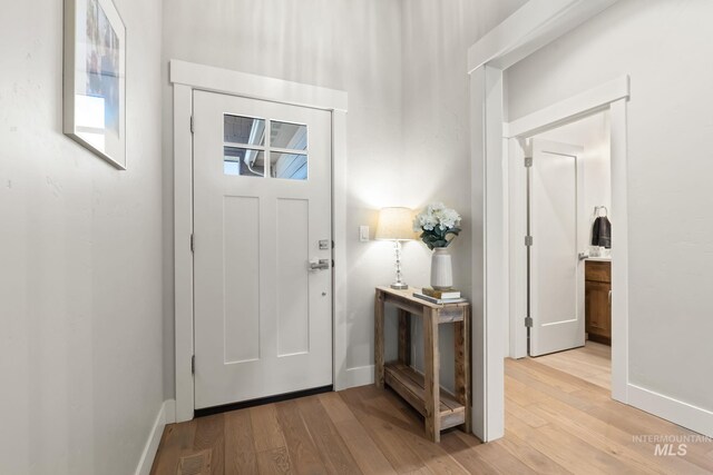 foyer with light wood finished floors and baseboards