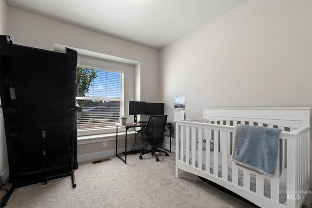 carpeted bedroom with a desk and baseboards