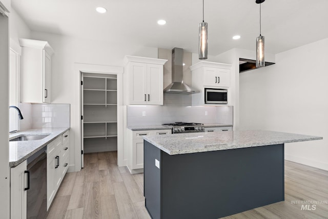 kitchen with wall chimney exhaust hood, a center island, white cabinetry, and sink