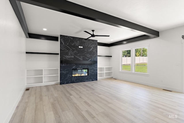 unfurnished living room featuring a fireplace, light wood-type flooring, and ceiling fan