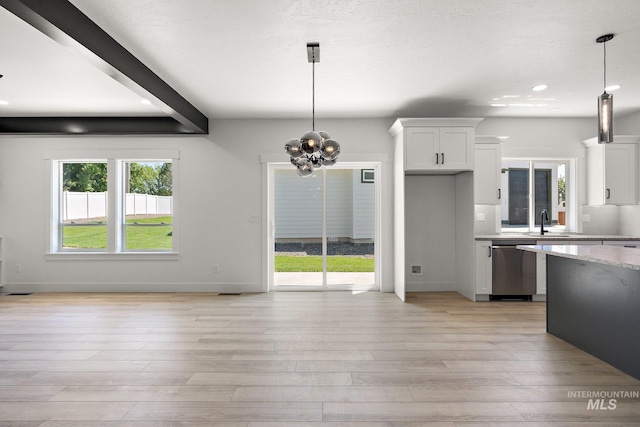 kitchen featuring white cabinets, dishwasher, light stone counters, and hanging light fixtures