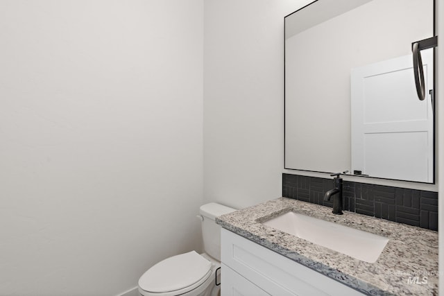 bathroom with vanity, tasteful backsplash, and toilet