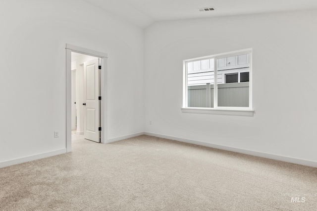 empty room with light carpet and vaulted ceiling