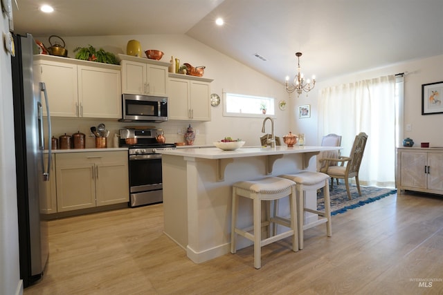 2431 Legacy Ct, Clarkston, WA 99403 - kitchen with stainless steel appliances, light countertops, vaulted ceiling, a kitchen breakfast bar, and a chandelier