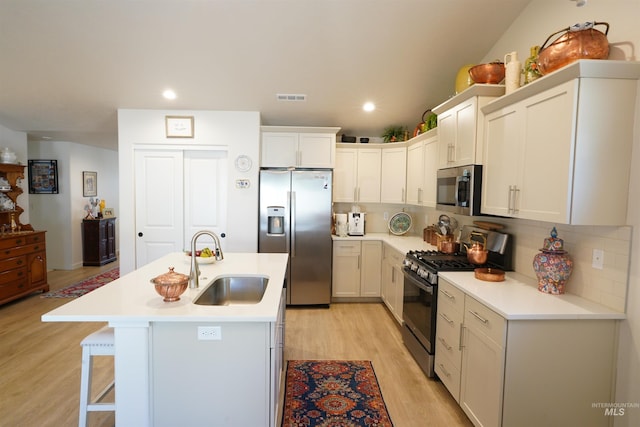 2431 Legacy Ct, Clarkston, WA 99403 - kitchen with stainless steel appliances, a sink, light wood finished floors, light countertops, and a kitchen breakfast bar