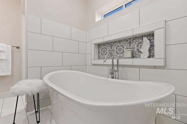 bathroom featuring a bathtub and tile walls