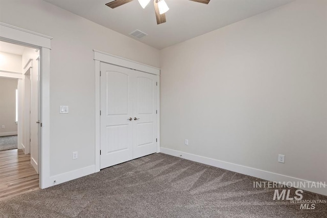 unfurnished bedroom with ceiling fan, a closet, and carpet