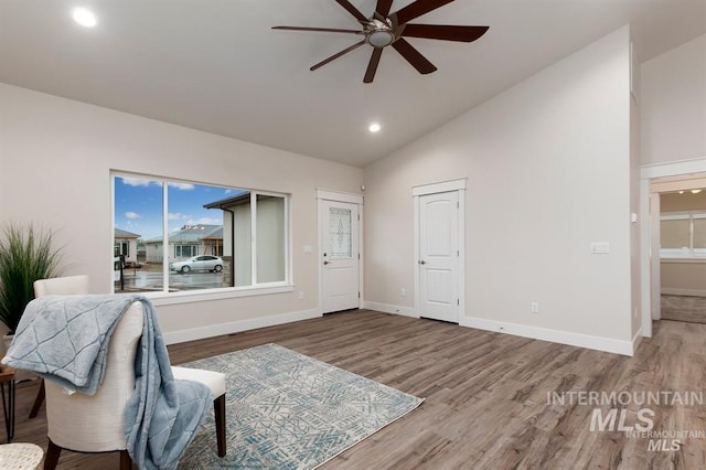 sitting room featuring wood-type flooring, high vaulted ceiling, and ceiling fan