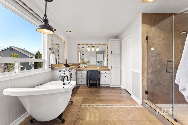 bathroom featuring a freestanding tub, a shower stall, vanity, and wood finished floors