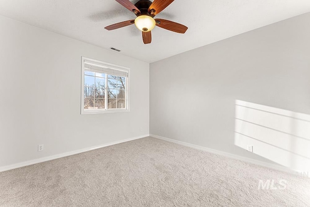 spare room featuring a ceiling fan, carpet, visible vents, and baseboards