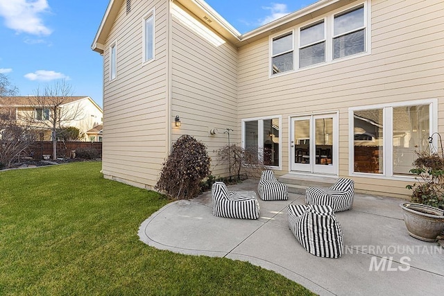 back of house with a yard and a patio