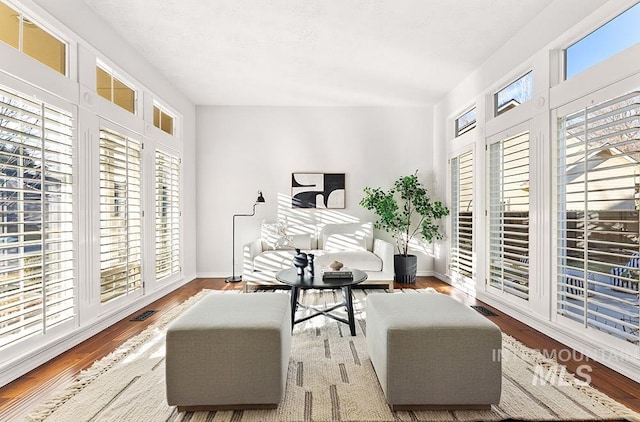 sitting room featuring wood finished floors, visible vents, and baseboards