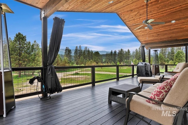 wooden deck with a ceiling fan and area for grilling