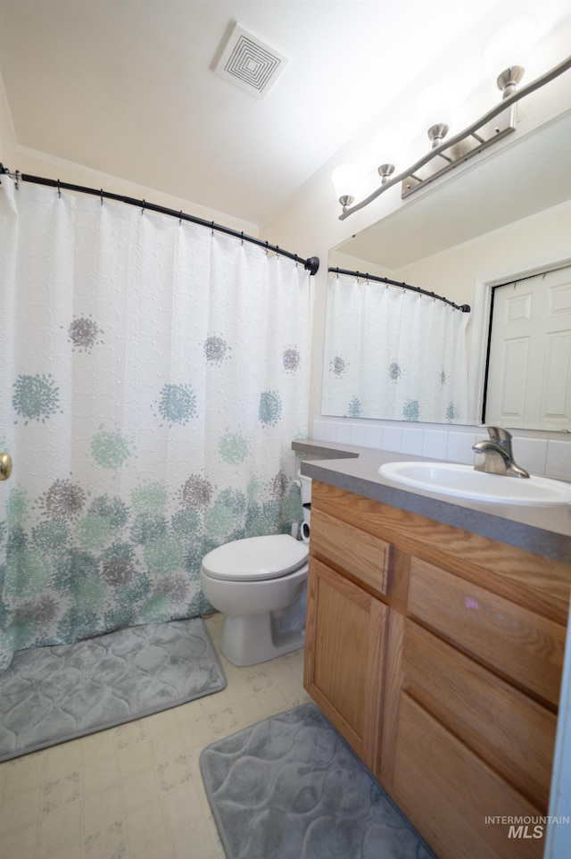 bathroom featuring vanity, tile patterned floors, toilet, and visible vents