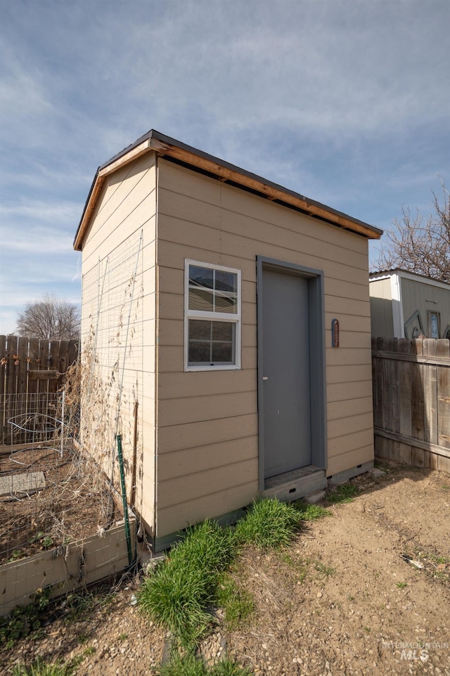 view of outdoor structure with a vegetable garden, an outdoor structure, and fence