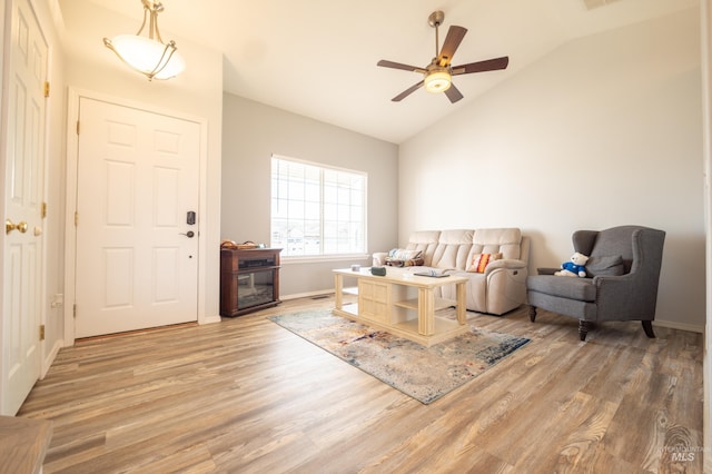 interior space featuring a ceiling fan, wood finished floors, baseboards, visible vents, and lofted ceiling