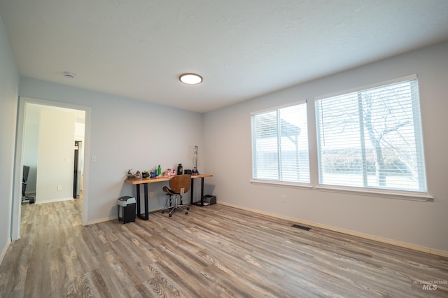 office with visible vents, baseboards, and wood finished floors