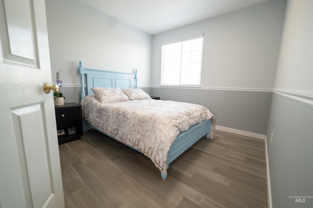 bedroom with baseboards and wood finished floors