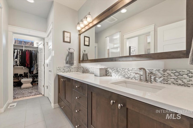 bathroom featuring tile patterned floors, vanity, and backsplash