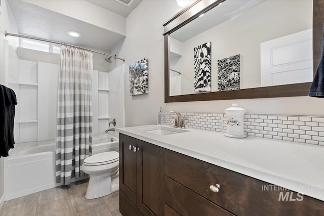 full bathroom featuring vanity, shower / tub combo with curtain, backsplash, and toilet