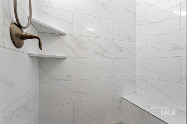 interior details featuring a tile shower