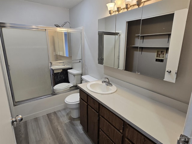 full bathroom with toilet, vanity, hardwood / wood-style floors, and enclosed tub / shower combo