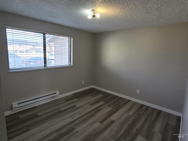 spare room featuring a baseboard radiator, a textured ceiling, and dark hardwood / wood-style flooring