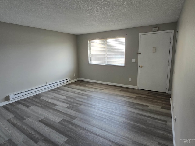 spare room featuring a textured ceiling, hardwood / wood-style floors, and baseboard heating