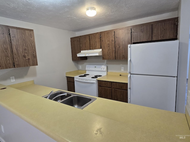 kitchen featuring white appliances, sink, and a textured ceiling