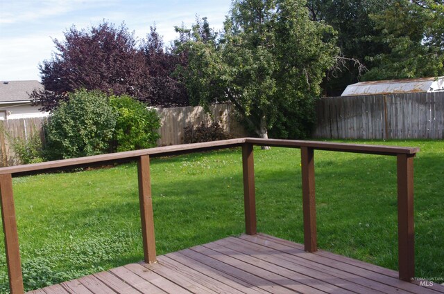 wooden deck featuring a lawn