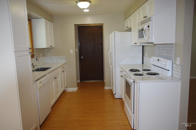 kitchen with sink, tasteful backsplash, light hardwood / wood-style floors, white appliances, and white cabinets