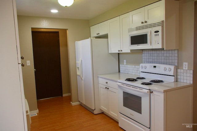 kitchen featuring white cabinets, light wood-type flooring, white appliances, and backsplash