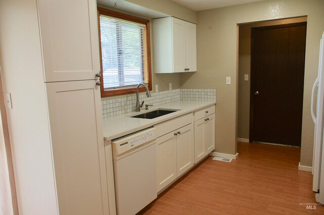 kitchen featuring sink, white cabinets, white appliances, and light hardwood / wood-style flooring