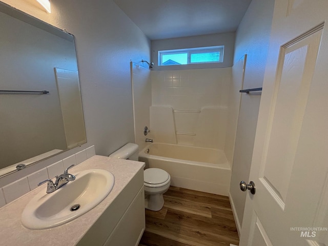 full bathroom featuring wood-type flooring, bathtub / shower combination, toilet, and vanity