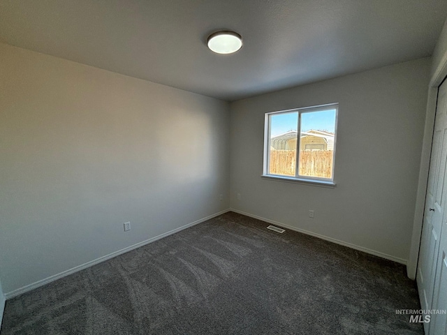 unfurnished bedroom with dark colored carpet