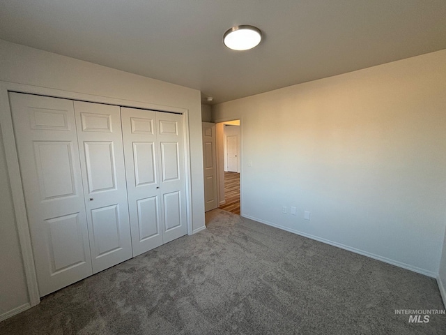 unfurnished bedroom with a closet and carpet floors