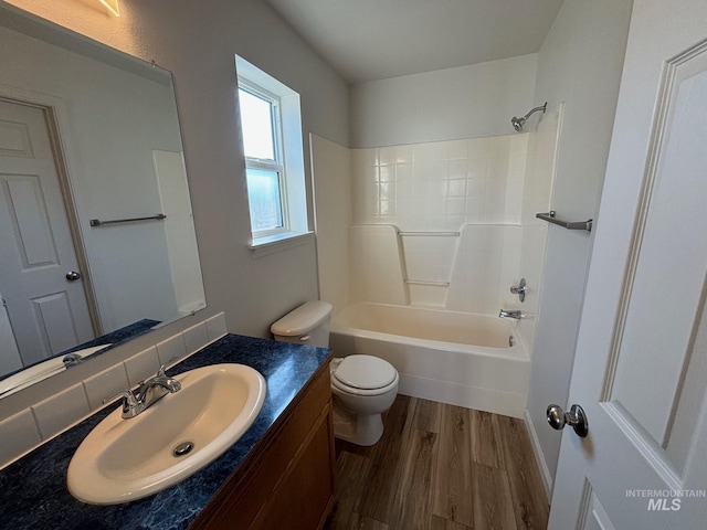 full bathroom with toilet, hardwood / wood-style floors, decorative backsplash, shower / bathing tub combination, and vanity