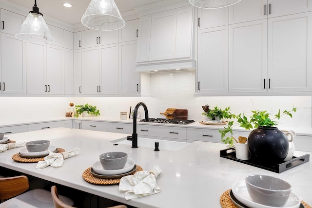 kitchen with a kitchen bar, custom exhaust hood, white cabinets, and light countertops