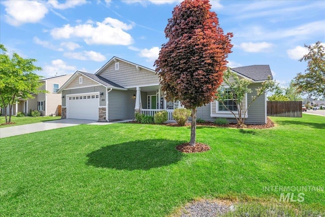 view of front of house featuring an attached garage, covered porch, driveway, and stone siding