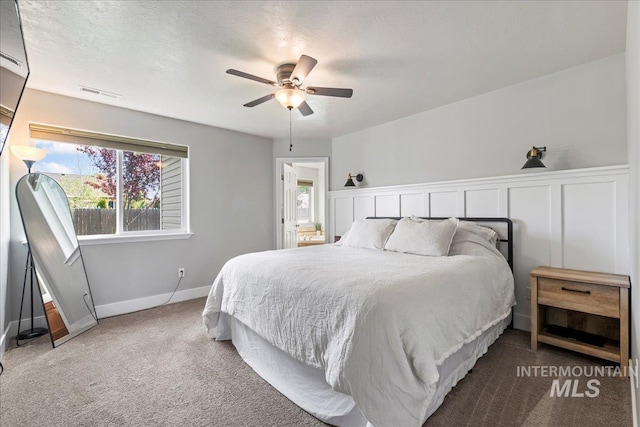 carpeted bedroom featuring baseboards and a ceiling fan