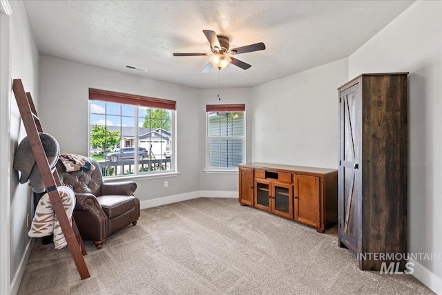 sitting room with carpet floors, ceiling fan, and baseboards