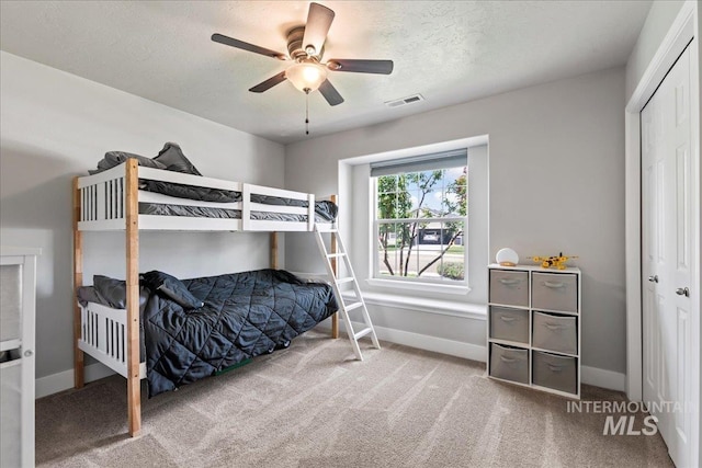 bedroom featuring carpet, baseboards, a textured ceiling, and ceiling fan